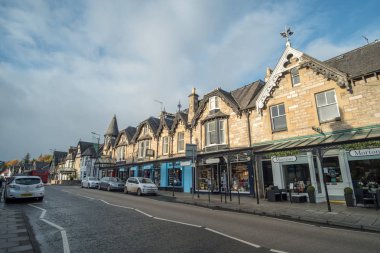 Pitlochry, İngiltere - 10 Kasım 2017: nehir Tummel yalan Pitlochry, Perthshire İlçesi İskoçya'da bir burgh ana cadde üzerinde yürüyen insanlar