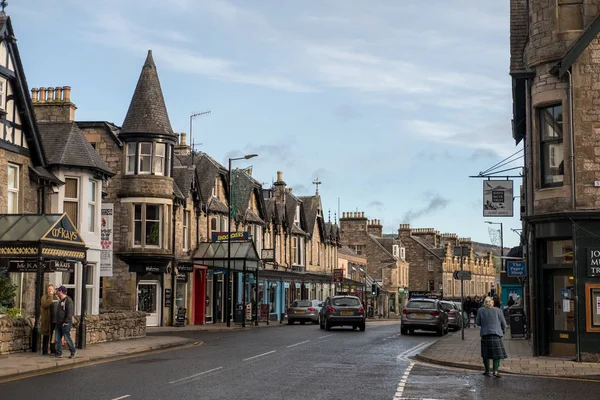 Pitlochry, İngiltere - 10 Kasım 2017: nehir Tummel yalan Pitlochry, Perthshire İlçesi İskoçya'da bir burgh ana cadde üzerinde yürüyen insanlar