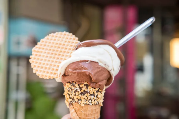 Çikolata ve süt Gelato, gözleme, dondurmayla tutan el arka plan bulanıklık.