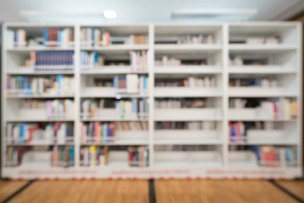 Blurred background of public library, bookshelf with books, education concept — Stock Photo, Image