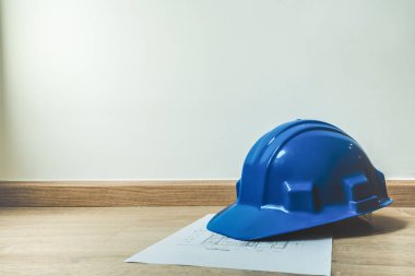 Emanet mavi kask ve ev yapımı planı, mimari ya da inşaat ya da sanayi ekipmanları, kopya alanı, mühendislik kavramı, yumuşak ışık sesi ile