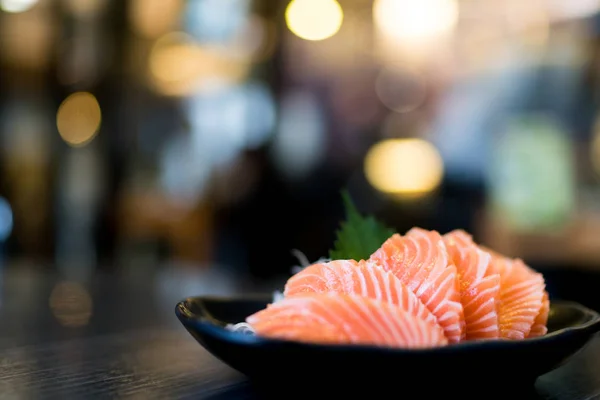 Sashimi de salmón en rodajas sobre mesa de madera, menú delicioso comida japonesa, fondo borroso bokeh con espacio para copiar —  Fotos de Stock