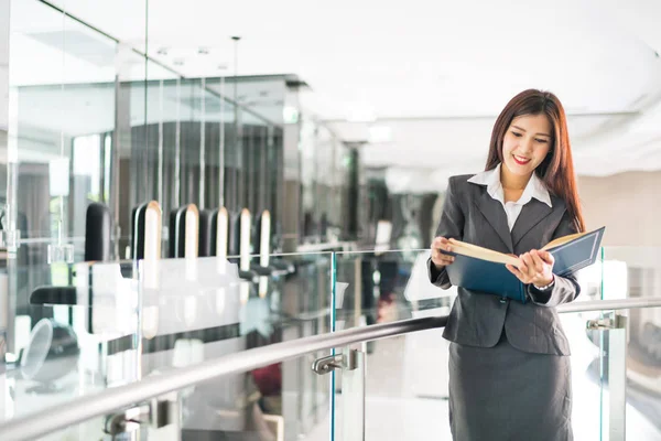 Mujer de negocios asiática o profesora universitaria leyendo libro de texto en oficina moderna, concepto de negocios o educación — Foto de Stock