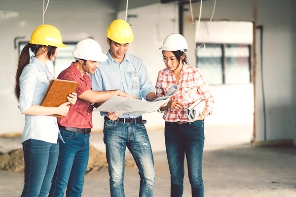 Multiethnic diverse group of engineers or business partners at construction site, working together on building's blueprint, architect engineering industry or teamwork concept — Stock Photo, Image