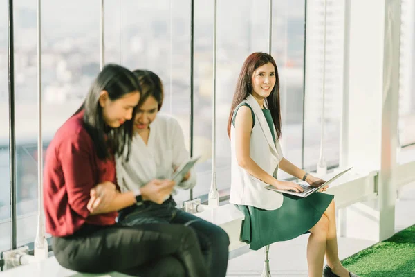 Hermosas chicas asiáticas usando portátil portátil y tableta digital durante el descanso de la oficina al atardecer, estilo de vida moderno con tecnología de gadget o mujer trabajadora en concepto de negocios casuales — Foto de Stock