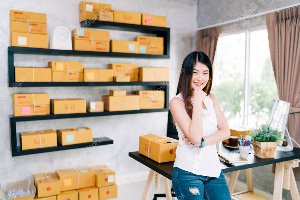 Young Asian small business owner at home office, online marketing packaging and delivery scene, startup SME entrepreneur or freelance woman working at home concept