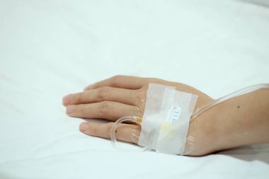 Hasta el ile serum fizyolojik IV damla hastane yatağında enjekte. Sağlık, tıbbi veya sigorta kavramı. Kopya alanı ile