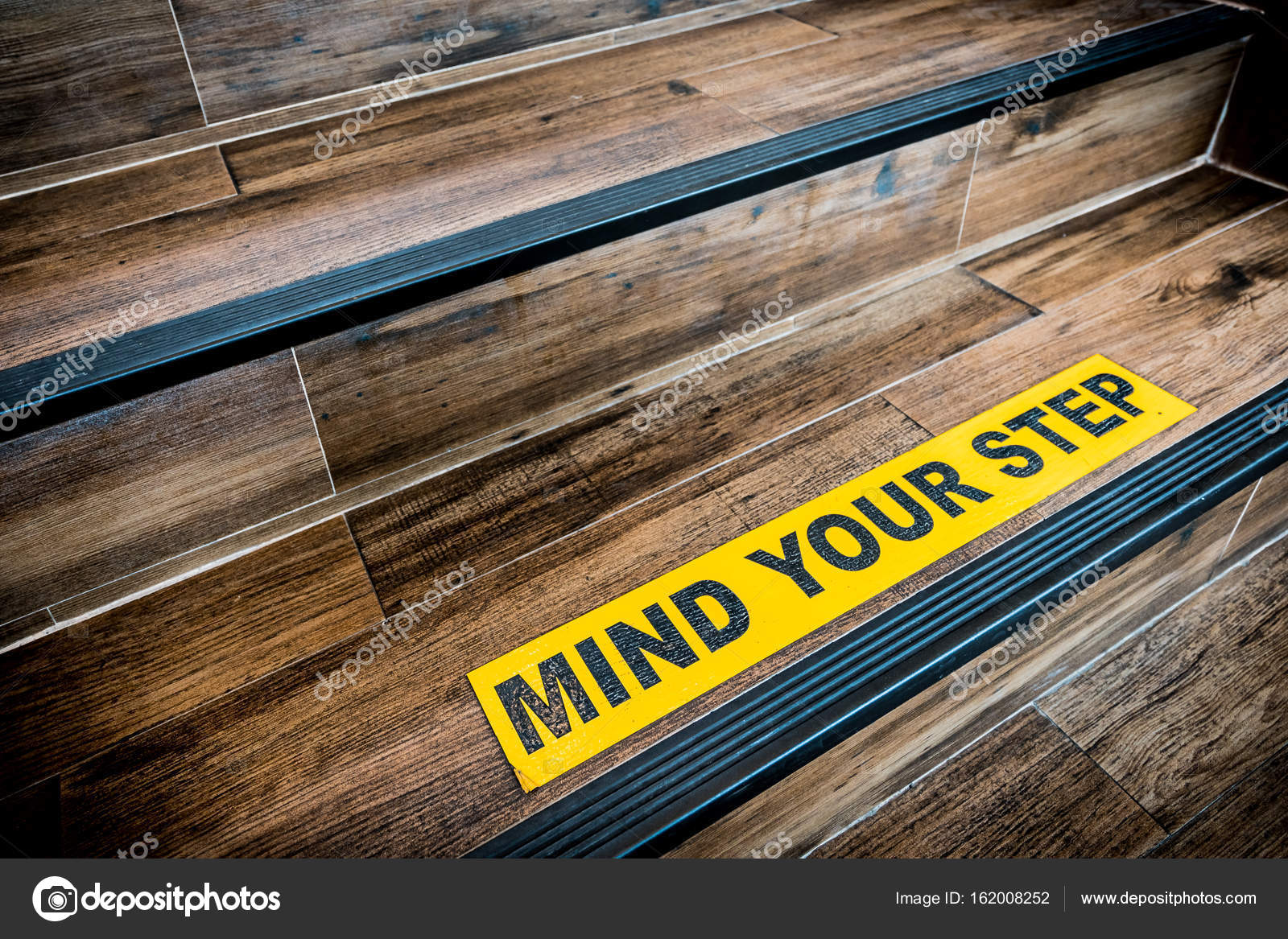 Mind Your Step Sticker Sign Pasted On Wooden Stair. Warnings.