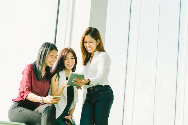 Tres hermosas chicas asiáticas utilizando tableta digital juntos. Mujer trabajadora o estudiantes universitarios charlando en la oficina con espacio para copias. Estilo de vida moderno con tecnología de gadget o concepto de negocio casual — Foto de Stock