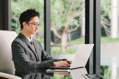 Yakışıklı Asya işadamı veya dizüstü bilgisayar ve dijital tablet kullanma executive office girişimci, iş yerinde. Liderlik, iş iletişim, başlangıç veya bilgi teknoloji gadget kavramı