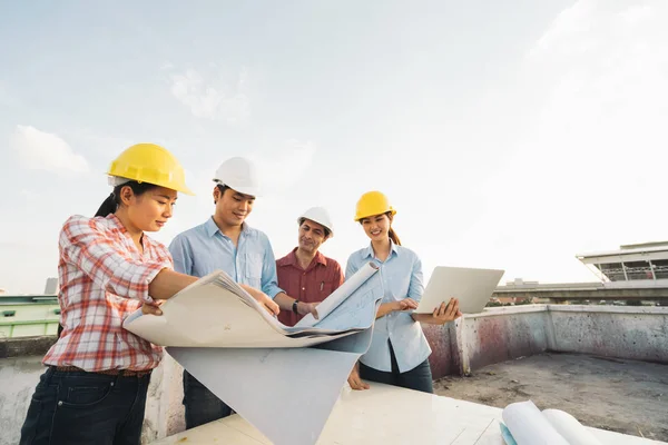 Multiethnic diverse group of engineers or business partners at construction site, working together on building's blueprint, architect industry or teamwork concept — Stock Photo, Image