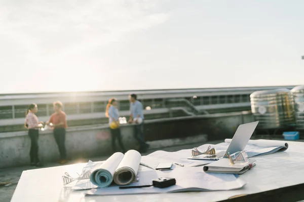 Ingenieurs en architecten ontspannen na het werk op de bouwplaats. Focus op gebouw blauwdrukken, laptopcomputer en hulpmiddelen voor burgerlijke bouwkunde. Industrie projecten of teamwerk concept — Stockfoto