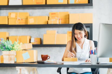 Genç Asyalı küçük işletme sahibi evde çalışma office, satınalma siparişlerinde not alma. Online Pazarlama ambalaj teslimat, başlangıç KOBİ girişimci veya serbest kadın kavramı