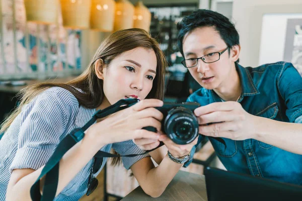 Joven pareja asiática aprendiendo a usar la cámara digital sin espejo juntos en la cafetería, moderno concepto de tecnología de gadget, se centran en la chica, profundidad del efecto de campo — Foto de Stock