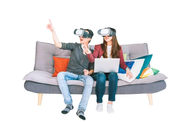 Young Asian couple playing VR virtual reality gadget, sitting on sofa together, isolated on white background. Modern entertainment technology, VDO game devices, or family hobby activity concept — Stock Photo, Image