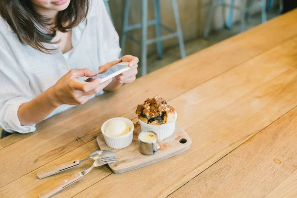 Chica asiática tomando fotos de pastel de chocolate tostado, helado y leche en la cafetería. Postres o comida fotografía hobby. Concepto de hábito de fotografía de teléfonos inteligentes o móviles. Con espacio de copia —  Fotos de Stock