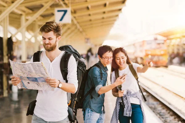 Multi-etnische groep rugzak reizigers met kaart en smartphone navigatie op treinstation, Aziatische toerisme activiteit of het concept van de technologie van de mobiele telefoon — Stockfoto
