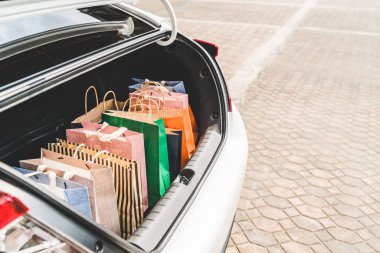 Shopping bags in car trunk or hatchback, with copy space. Modern shopping lifestyle, rich people or leisure activity concept clipart