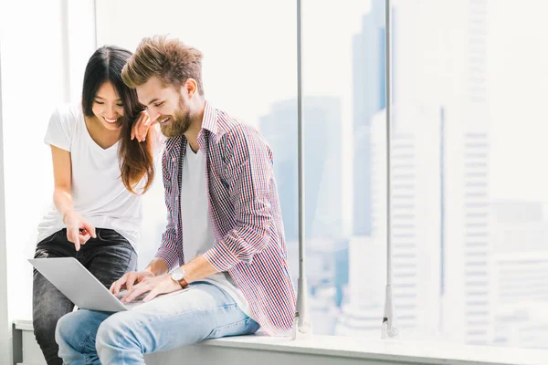 Jeune couple multi-ethnique ou étudiant utilisant un ordinateur portable portable ensemble sur le campus ou au bureau. Technologies de l'information, éducation, création d'entreprise ou concept de style de vie moderne. Avec espace de copie — Photo