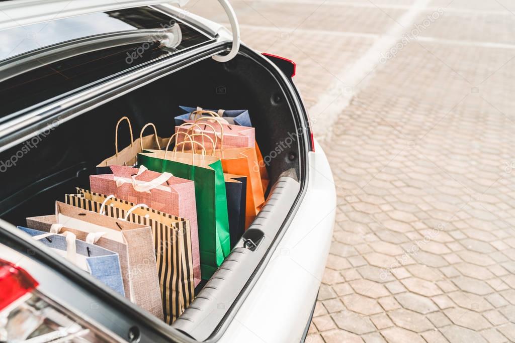 Shopping bags in car trunk or hatchback, with copy space. Modern shopping lifestyle, rich people or leisure activity concept