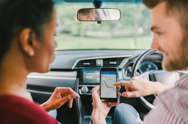 자동차에서 스마트 폰에 네비게이션 시스템을 사용하여 다민족 다양한 연인 커플. 휴대 전화 응용 프로그램, 크라우드 소싱 택시 또는 타고 우박 응용 프로그램 서비스, 현대 가제트 또는 가족 여행 라이프 스타일 개념 — 스톡 사진
