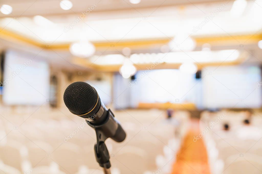 Microphone stand in conference hall blurred background with copy space. Public announcement event, Organization company meeting, live performance media, or graduation education award ceremony concept