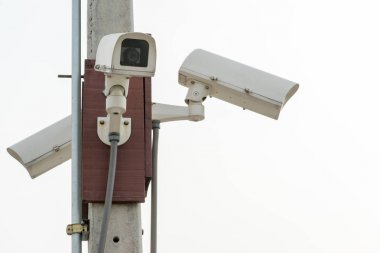 Three surveillance security cameras on white sky background with copy space. Modern safety technology concept clipart