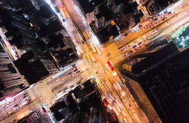 Car, taxi, and bus traffic on road intersection at night in Hong Kong downtown district, drone aerial top view. Street commuter, Asia city life, or public transportation concept clipart