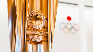 Tokyo, Japonya - 1 Kasım 2019: Tokyo Yaz Olimpiyatları 'nın altın kupası 2020 Japonya Olimpiyat Müzesi' nde sergi, arka planda Olimpiyat oyunları logosu. Uluslararası spor etkinliği veya turnuva ev sahibi ülke konsepti