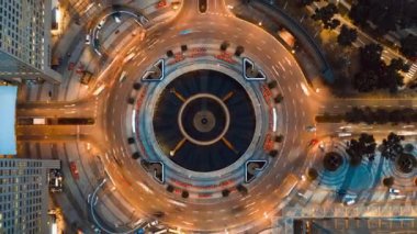 Singapur 'daki zenginlik çeşmesinin etrafındaki kavşakta 4K' lık bir zaman atlamalı araç trafiği, insansız hava aracı üst görüntüsü, uzaklaşın. Ulaşım teknolojisi, şehir hayatı, Asya seyahati konsepti