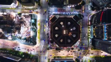 4K hızlandırılmış araba trafiği ulaşımı ve inşaat sahasında, gece şehir merkezinde vinç. İnsansız hava aracı üst görüntüsü. Sanayi veya inşaat mühendisliği teknolojisi kavramı