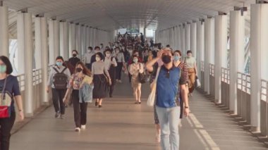 Bangkok, Tayland - 7 Nisan 2020: Kalabalık Asyalılar yaya yolunda yürürken maske takıyor. Coronavirus hastalığı Covid-19 salgını, şehir hayatı veya hava kirliliği konsepti. 4K ağır çekim