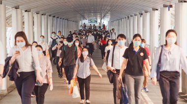 Daha az kalabalık Asyalılar yaya geçidinde maske takıyor. Coronavirus hastalığı Covid-19 salgını insan toplumu, sosyal uzaklaşan şehir hayatı veya 2.5. Hava kirliliği kavramı
