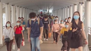 Bangkok, Tayland - 7 Nisan 2020: Kalabalık Asyalılar yaya geçidinde yüz maskesi takıyor, sabah trafiği. Coronavirus hastalığı Covid-19 salgını, şehir hayatı veya hava kirliliği konsepti