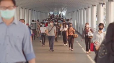 Bangkok, Tayland - 7 Nisan 2020: Kalabalık Asyalılar yaya geçidinde yüz maskesi takıyor, sabah trafiği. Coronavirus hastalığı Covid-19 salgını, şehir hayatı veya hava kirliliği konsepti