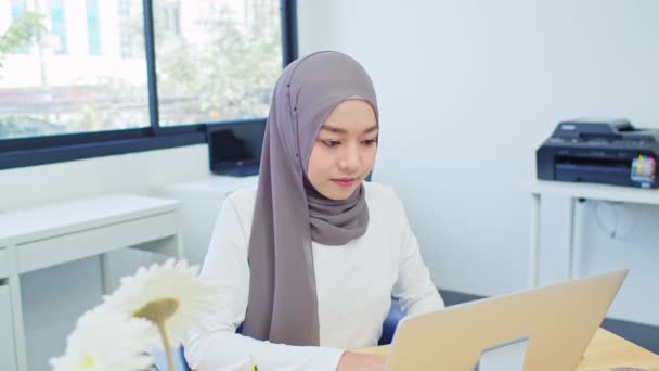 現代のホームオフィスでラップトップを使用して美しいアジアのイスラム教徒の女性 中小企業経営者 起業家 自宅での仕事 またはコロナウイルス危機の概念中に働く自己分離リモート — ストック動画