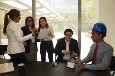 Mimar, evin müstakbel sahibine faydalarının kavramsal bir maketini kullanarak açıklar, karısı ise Mexico City 'deki bir ofiste yetkili personelle imzalanacak sözleşmeyi analiz eder.