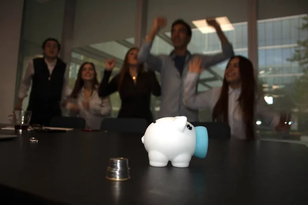 Office workers jumping from happiness in Mexico City office to receive annual savings from the piglet