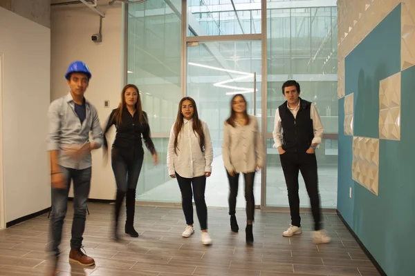 Employees on the move with relaxed clothes walking in office in Mexico