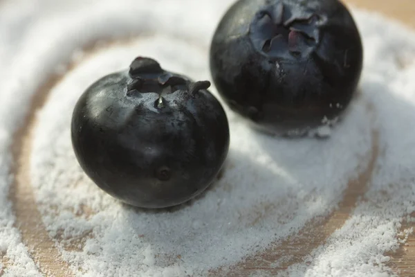 Sugar substitute granules with a simulated heart wrapping a pair of blueberries to develop sugar-free desserts