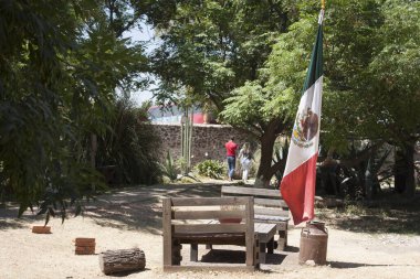 Meksika 'daki bahçe bahçesinde, merkezinde eski metal bir süt kutusu bulunan ulusal bayrak var.