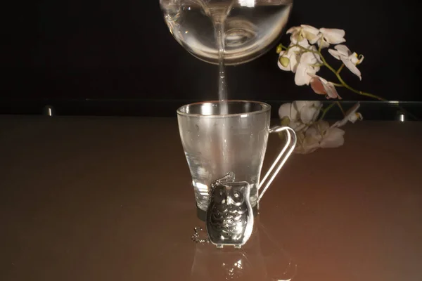 お湯で満たされた透明なガラスのカップの中で花の本質を抽出し — ストック写真