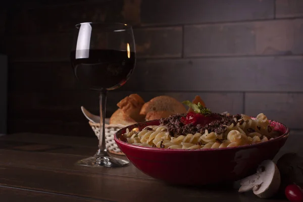 A suggestive dinner in the light of the candles, with pasta and red wine