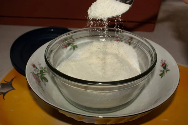 Spoonful of glass sugar adding to a bowl