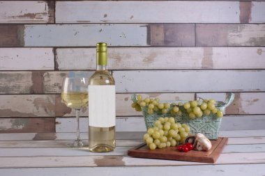 White wine vellum next to a glass served cold to accompany with refreshing grapes clipart