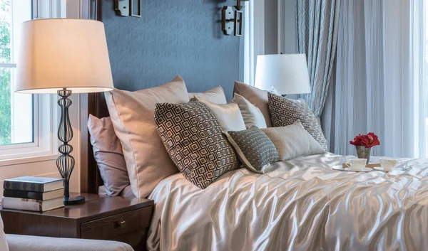 Intérieur de chambre de luxe avec des oreillers de motif brun et plateau décoratif de fleur sur le lit — Photo