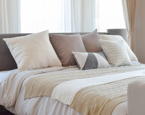 Stylish bedroom interior design with brown patterned pillows on bed and decorative table lamp. — Stock Photo, Image