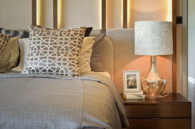 resim çerçevesi üzerinde ahşap masa ile beyaz lamba lüks yatak odası