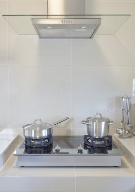stainless pan on gas stove with utensil in modern kitchen clipart