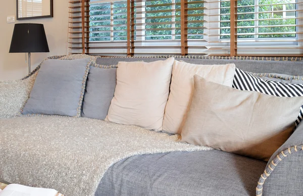Εσωτερικό σαλόνι με μαξιλάρια στον καναπέ και διακοσμητικά ξύλινο τραπέζι με φανό — Φωτογραφία Αρχείου